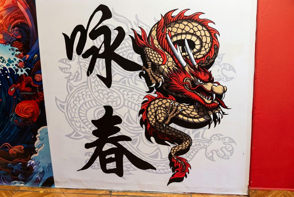 El mural del segundo piso: un dragón rojo y dorado junto a los caracteres 咏春